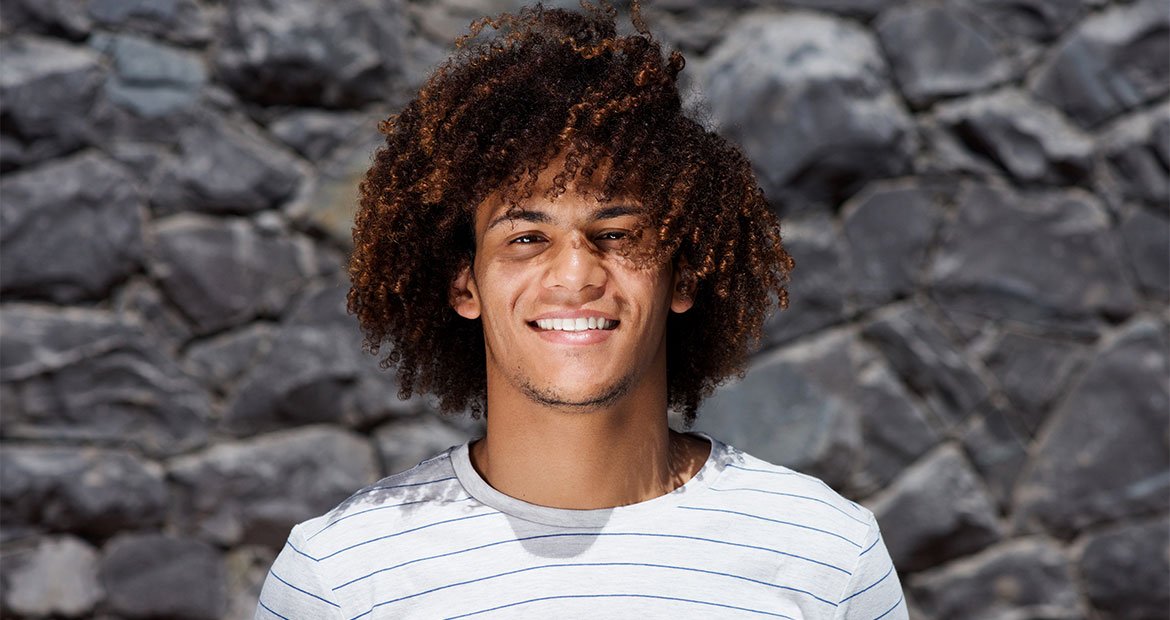Jovem com o cabelo cacheado masculino grande